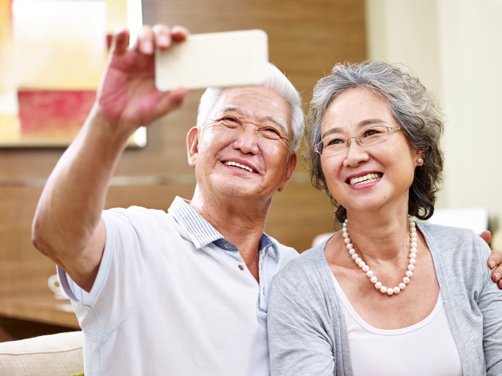 senior-asian-couple-taking-a-selfie-picture-id623377194